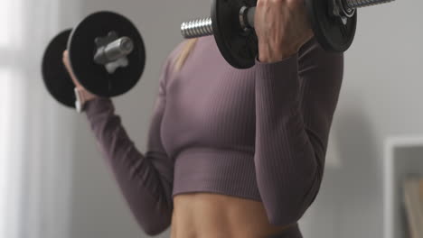 Eine-Sportliche-Frau-Hebt-Hanteln-Und-Trainiert-Die-Muskeln-Von-Händen-Und-Brust.-Detailansicht-Des-Körpers.-Sportliche-Aktivitäten-Und-Ein-Gesunder-Lebensstil-Halten-Frauen-Fit